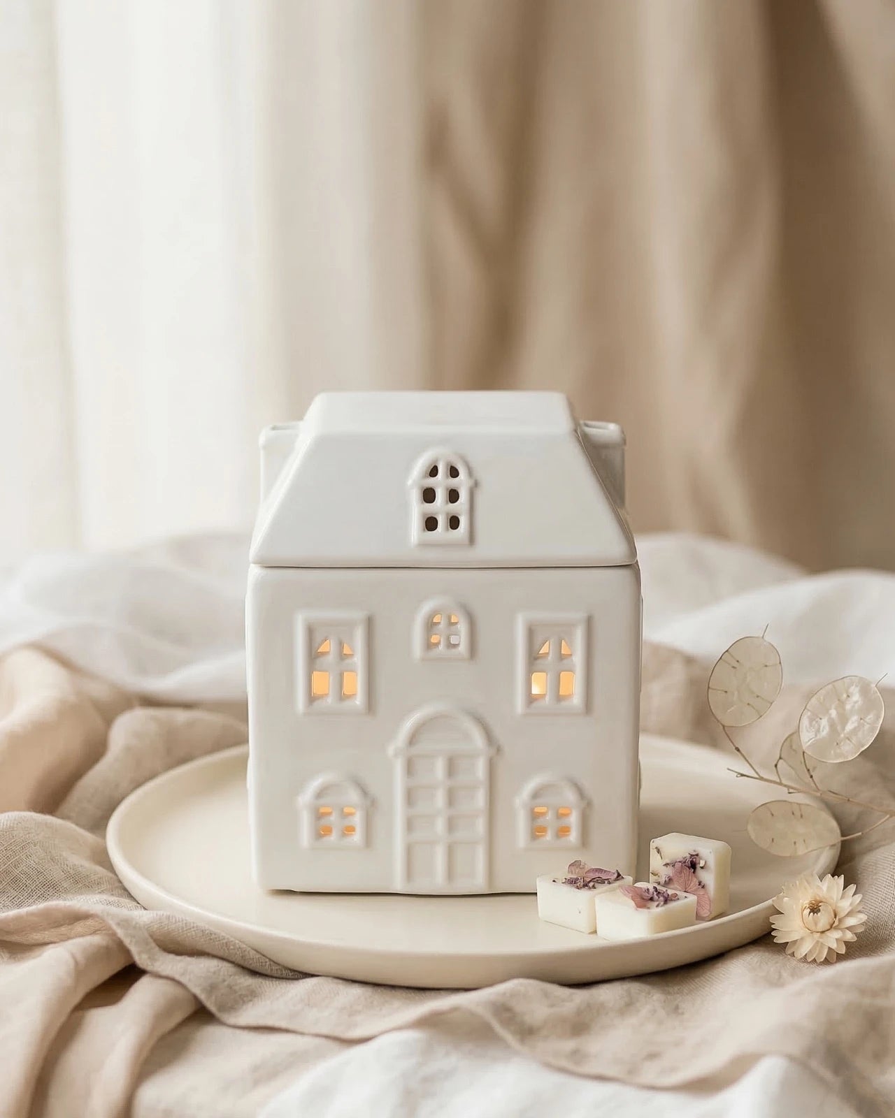 Bruciatore di cera ceramica in ambiente domestico, stile slow living japandi
