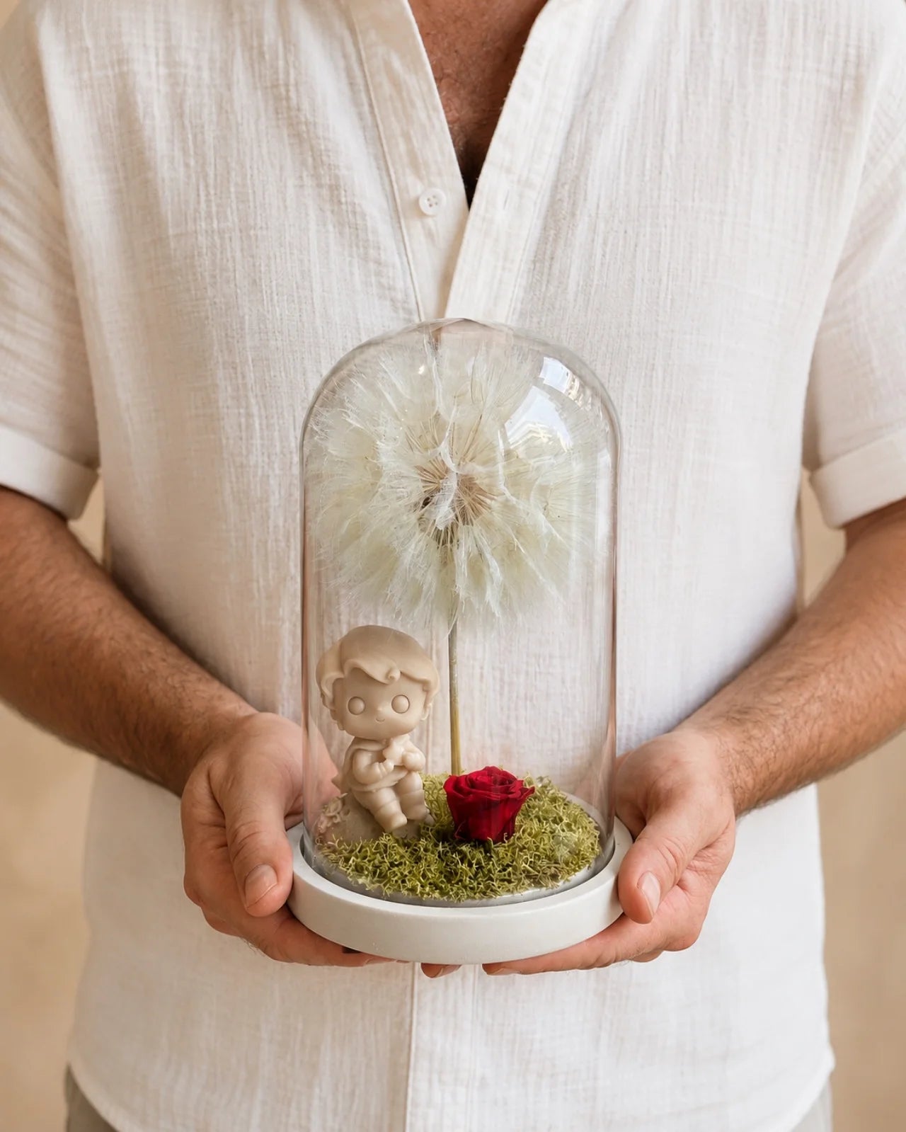 L'Essentiel — campana di vetro con miniatura del Piccolo Principe in cera profumata, rosa rossa stabilizzata, soffione Tragopogon e muschio botanico. 