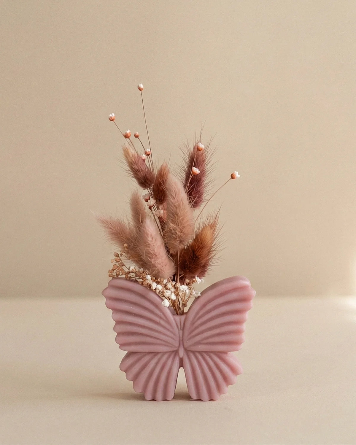 Vaso di cera a forma di farfalla con bouquet di fiori secchi e stabilizzati, creazione artigianale simbolo di rinascita color rosa cipria antico